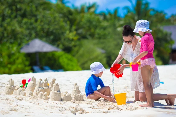 Meninas adoráveis e mãe feliz brincando com brinquedos de praia em férias de verão — Fotografia de Stock