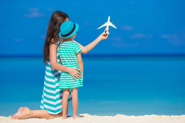 Młoda kobieta i dziewczynka z miniaturowe samolotu na plaży — Zdjęcie stockowe