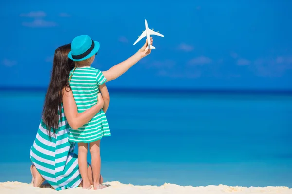 Młoda kobieta i dziewczynka z miniaturowe samolotu na plaży — Zdjęcie stockowe
