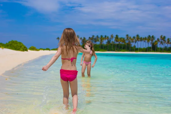 Çok güzel mutlu küçük kızlar sığ su plaj tatil iyi eğlenceler — Stok fotoğraf