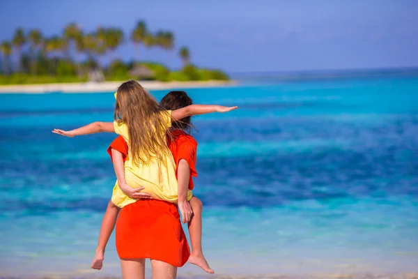 Niña y madre joven durante las vacaciones en la playa —  Fotos de Stock