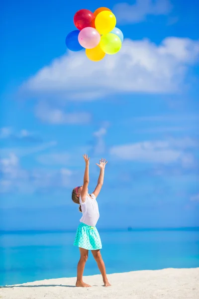 Rozkošná holčička hraje s barevnými balónky na tropické pláži — Stock fotografie