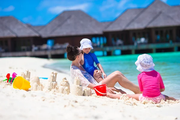 Adorables niñas y madre feliz jugando con juguetes de playa en las vacaciones de verano —  Fotos de Stock