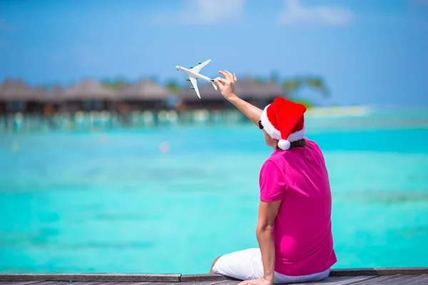 Ung i santa hatt under strandsemester på trä brygga — Stockfoto