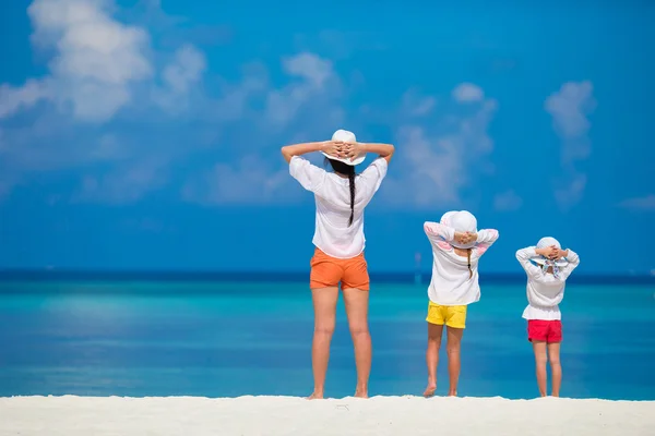 Schattige kleine meisjes en jonge moeder op tropisch wit strand — Stockfoto