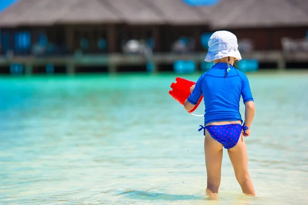 Очаровательная девушка играет с пляжными игрушками во время тропического отдыха — стоковое фото