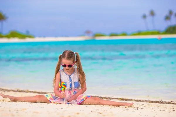 Adorable little girl with lollipop on tropical beach vacation — Stock Photo, Image
