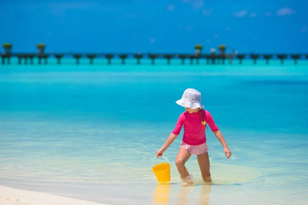 Adorable happy little girl at shallow water with beach toys — Stock Photo, Image