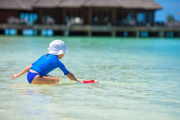 Rozkošný dívka si hraje s hračkami, beach během tropické dovolené — Stock fotografie