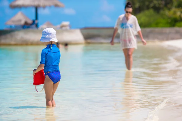 Mała dziewczynka i szczęśliwą matką podczas wakacji na plaży — Zdjęcie stockowe