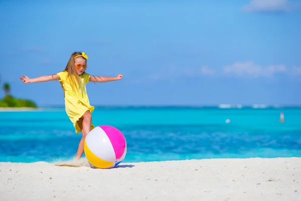 Rozkošná holčička hraje na pláži s míčem venkovní — Stock fotografie