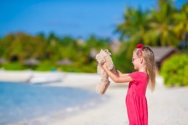 Adorable little girl playing with plush toy on beach — Stock Photo, Image