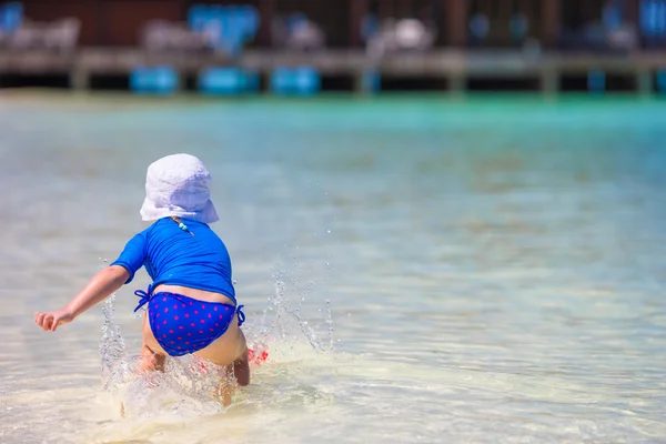 Adorable niña feliz divertirse en aguas poco profundas en vacaciones de playa —  Fotos de Stock