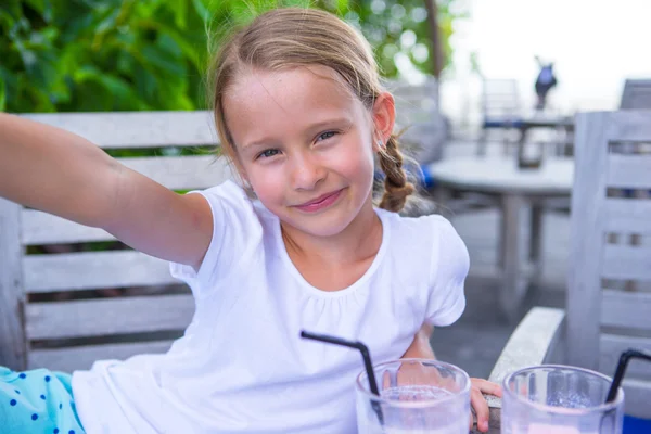 Kleine Mädchen machen Selfie und trinken leckere Cocktails im Outdoor-Café — Stockfoto