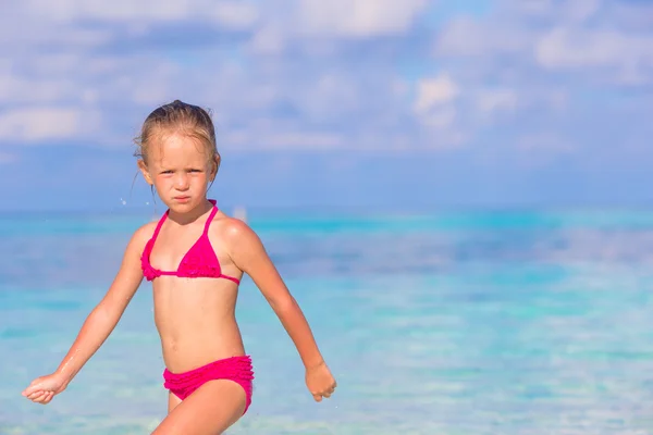 Adorable happy little girl have fun at shallow water on beach vacation — Stock Photo, Image