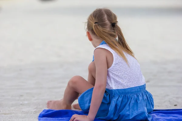 Adorável menina sentada na cadeira na praia tropical — Fotografia de Stock