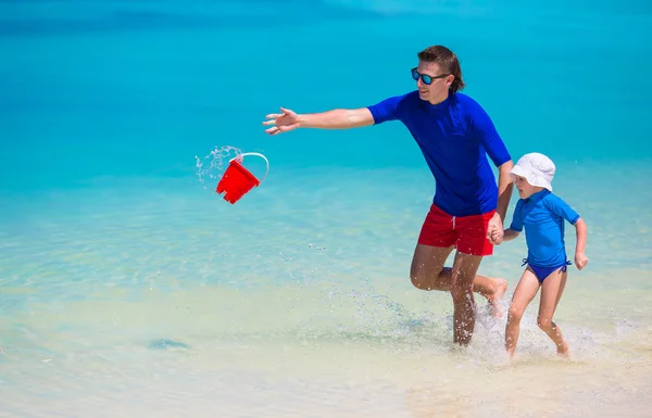 Buon padre e piccola figlia si divertono sulla spiaggia tropicale — Foto Stock