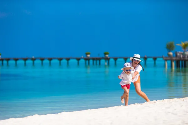 小小快乐的女孩和年轻的母亲在海滩度假 — 图库照片