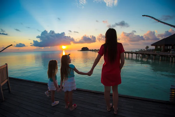 Silhouette of young mother and two her little girls at sunset — Stock Photo, Image