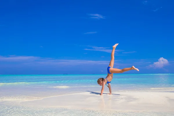 Adorável menina feliz se divertir em águas rasas em férias na praia — Fotografia de Stock