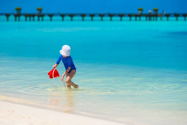 Чарівна щаслива маленька дівчинка розважається на мілководді на пляжі — стокове фото