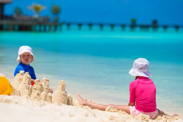 Dos niños haciendo castillo de arena y jugando en la playa tropical —  Fotos de Stock