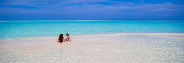 Niña y madre joven durante las vacaciones en la playa — Foto de Stock