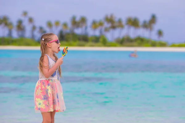 Adorable niña con piruleta en vacaciones en la playa tropical — Foto de Stock