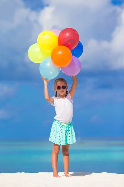 Bedårande liten flicka spelar med ballonger på stranden — Stockfoto