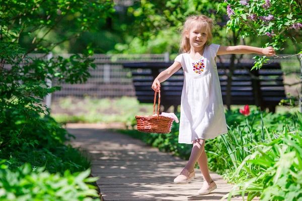 Pequena menina adorável com flores no jardim tulipas — Fotografia de Stock