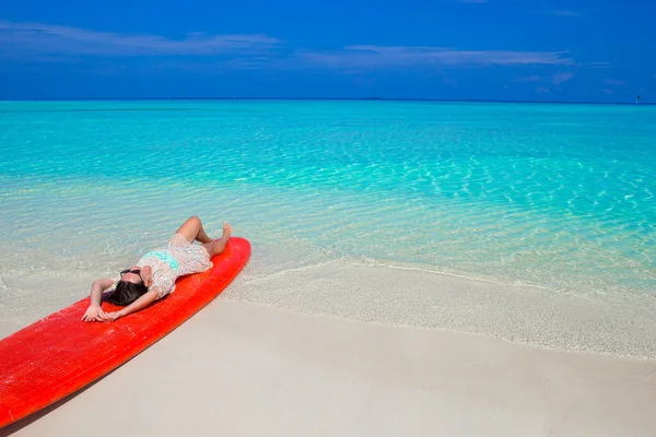 Young surfer woman at white beach on red surfboard — Stock Photo, Image