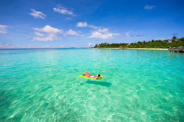 Woman relaxing on inflatable air mattress at turquoise water — Stock Photo, Image