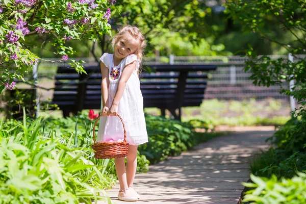 Kleines entzückendes Mädchen mit Blumen im Tulpengarten — Stockfoto