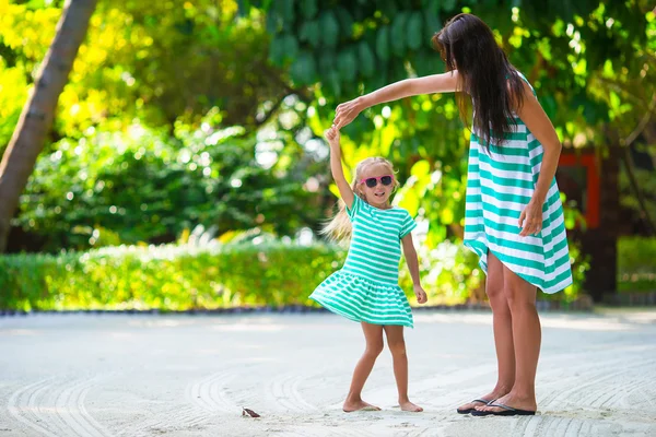 Entzückendes kleines Mädchen und glückliche Mutter im Urlaub am tropischen Strand — Stockfoto