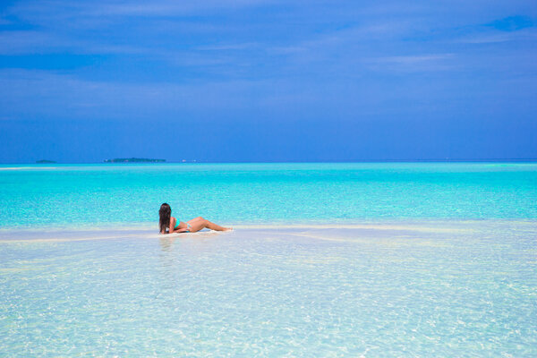 Young happy woman enjoy summer vacation on white sandy beach