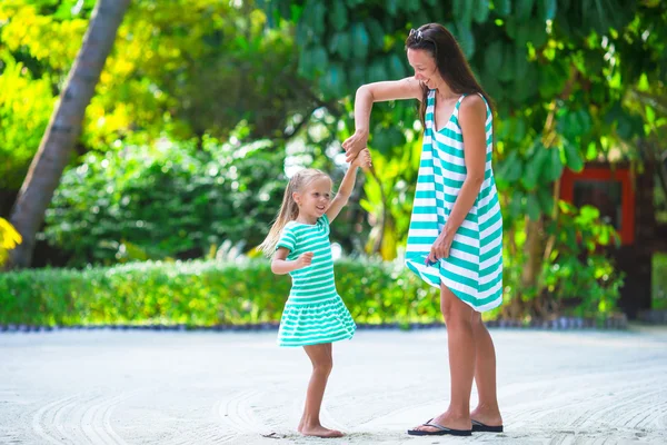 Adorable niña y feliz mamá durante las vacaciones en la playa tropical —  Fotos de Stock