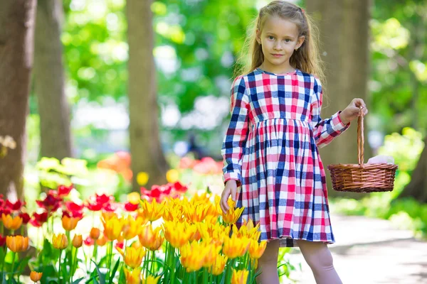 Little beautiful girl in tulips garden at warm spring day — Stock Photo, Image