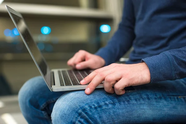 Empresario que usa computadora portátil o computadora portátil mientras está sentado en la silla en el aeropuerto —  Fotos de Stock