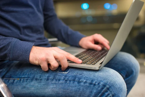 Empresario que usa computadora portátil o computadora portátil mientras está sentado en la silla en el aeropuerto —  Fotos de Stock