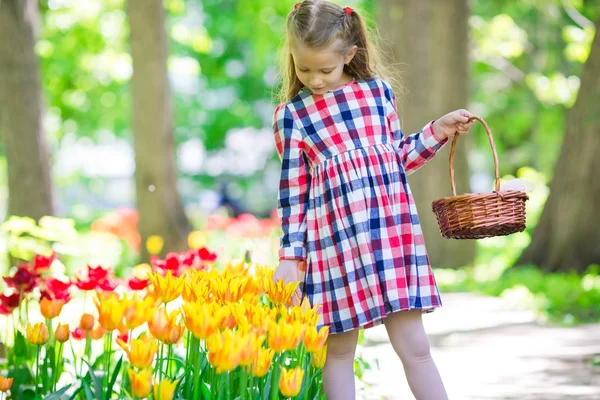 小可爱女孩与郁金香花园里的花 — 图库照片