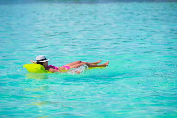 Frau entspannt sich auf aufblasbarer Luftmatratze am türkisfarbenen Wasser — Stockfoto