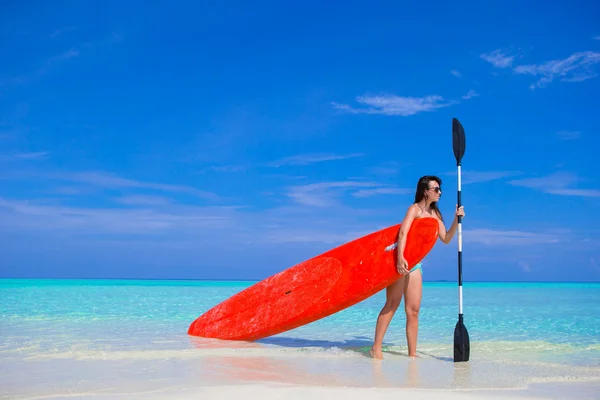 Happy young surf woman at the beach with a surfboard and paddle — Stock Photo, Image