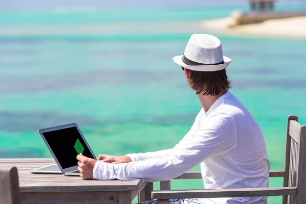 Young man with tablet computer on tropical beach — Stock Photo, Image