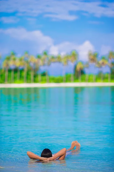 Young happy woman relaxing on white sandy beach — Stock Photo, Image