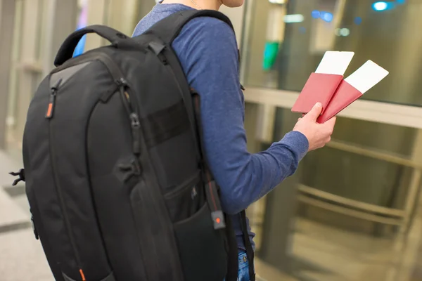 Closeup of man holding passports and boarding pass at airport — Stock Photo, Image