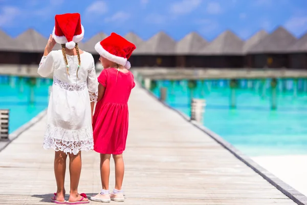 Bambine adorabili a Babbo Natale cappelli durante le vacanze al molo di legno — Foto Stock