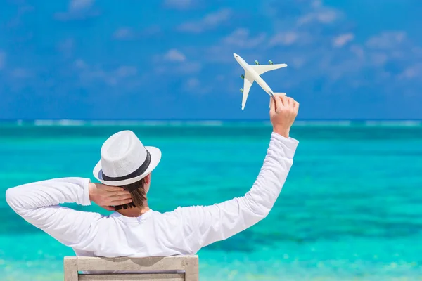 Jeune homme avec miniature d'un avion à la plage tropicale — Photo