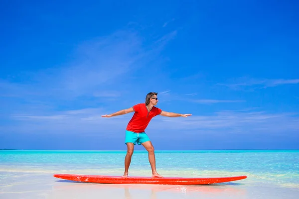 Sörf tahtası üzerinde sörf pozisyon pratik mutlu genç adam — Stok fotoğraf