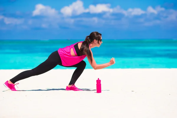 Gezonde atleet vrouw uitwerkend doen oefening op witte strand — Stockfoto