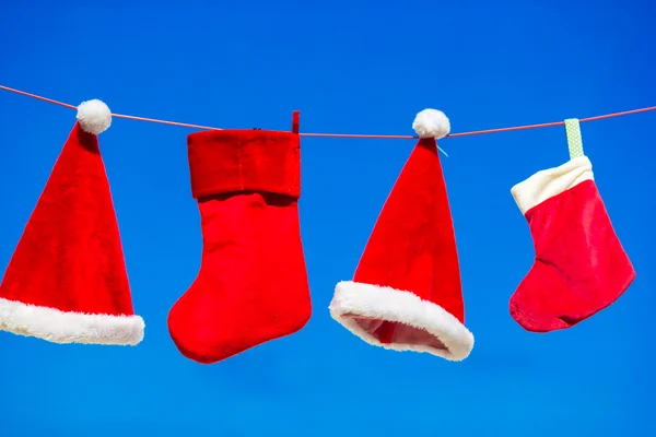 Red Santa hats and Christmas stocking hanging background blue sky — Stock Photo, Image